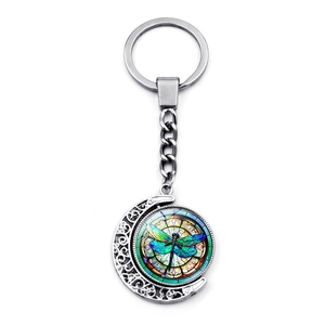 Creative silver moon keychain featuring a rotating colorful dragonfly glass pendant charm