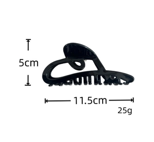 Detailed view of black acetate shark hair claw clip with size dimensions 11.5cm by 5cm