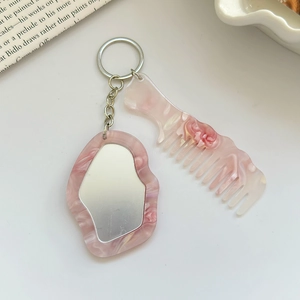 Detailansicht Schlüsselanhänger Set mit Spiegel und Kamm in rosa Marmoroptik auf Weiß