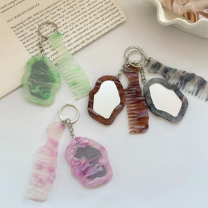 Schlüsselanhänger-Set aus Acryl in Wolkenform mit Marmortextur und Spiegel auf weißem Grund
