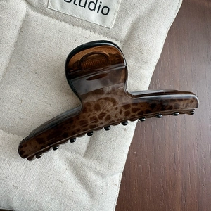 Detailed view of the leopard print resin hair claw clip showing amber tortoiseshell pattern