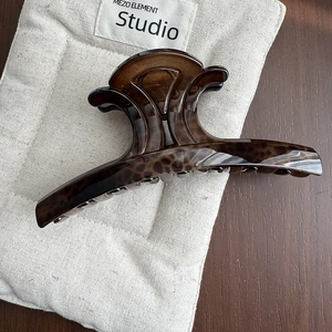 Close-up of leopard print hair claw clip on linen bag showing high gloss resin texture