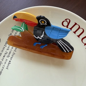Detailed view of creative toucan bird hair claw clip made of colorful acetate material
