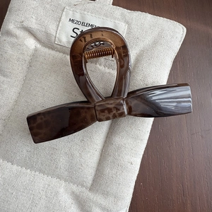 Elegant leopard print hair claw clip in tortoiseshell amber on a beige linen fabric mat