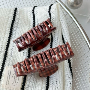 Detail view of two vintage checkered hair claws in cocoa brown with glossy finish