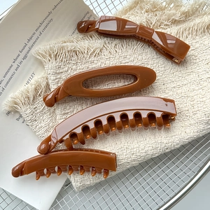 Set mit vier karamellbraunen, glänzenden Haarklammern im großen Hai-Clip-Design für Damen
