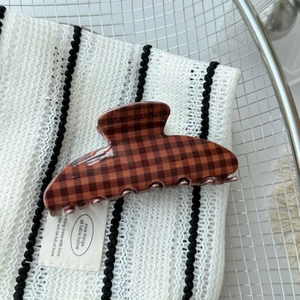 Detail view of the vintage brown checkered pattern on a sturdy hair claw clip