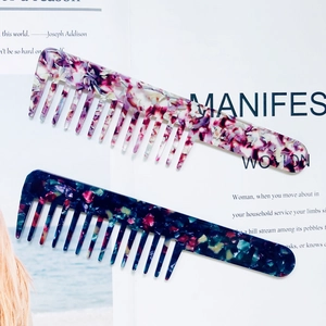 Acetate wide tooth hair combs with marble patterns on a minimalist magazine background