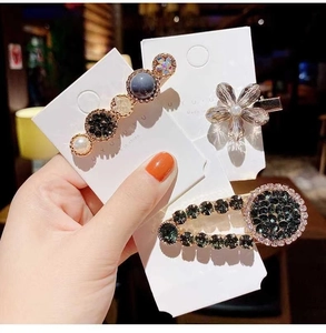 Detailed view of elegant pearl and rhinestone hair clips in three various designs