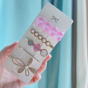 Detail view of 5-piece hair clip set with pink heart, pearls, rhinestones and butterfly shape