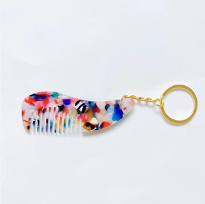 Détail d'un porte-clés peigne en acétate avec motifs de fleurs et écaille de tortue