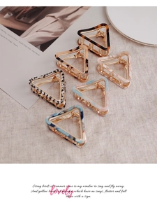 Detail of hollow triangle hair claws in tortoiseshell, checkerboard, and marble patterns