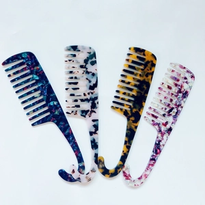 Set of four wide-tooth acetate combs with diverse tortoiseshell and marble patterns