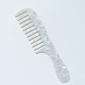 Detail of ergonomic handle and marble texture on acetate wide-tooth comb