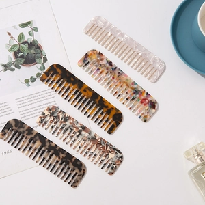 Macro detail of five acetate wide-tooth hair combs with elegant marble and tortoiseshell patterns