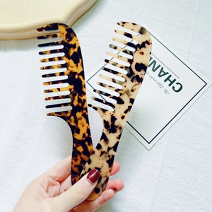 Detail of wide-tooth tortoiseshell acetate hair combs with ergonomic handle design