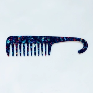 Macro view of blue marble acetate wide tooth hair comb with integrated handle hook