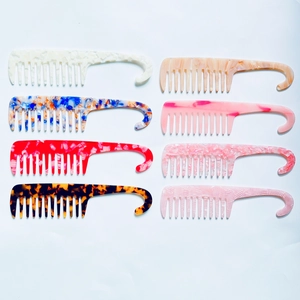 Collection of wide-tooth acetate hair combs with marble patterns and hanging hook handles