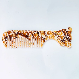 Détail d'un mini peigne en acétate avec motifs en écaille et silhouette d'ours