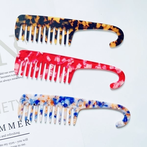 Three acetate wide-tooth hair combs in tortoiseshell, red marble, and floral with hooks
