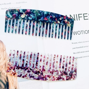 Detailed view of wide-tooth acetate hair combs with elegant marble floral patterns