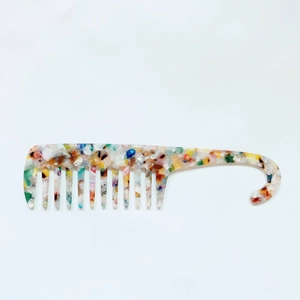 Detail of colorful acetate wide-tooth comb with hook handle and anti-static texture