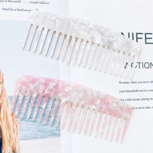 Detail view of marble pattern acetate hair combs on magazine background