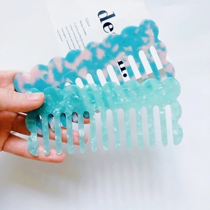 Detail of wavy acetate hair combs with blue and mint green marble textures