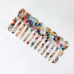 Detail of colorful marble acetate wide-tooth hair comb with wavy anti-slip top design