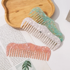 Trois peignes en acétate aux motifs marbrés vert menthe, blanc perle et rose corail
