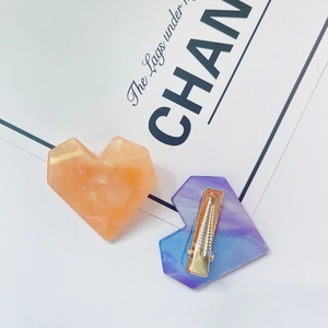 Close-up of marble pattern heart hair clip with a secure golden metal duckbill base