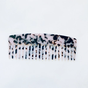 Detail of tortoiseshell acetate hair comb showing the marble texture and fine comb teeth