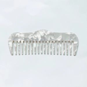 Détails du peigne à dents larges en acétate avec une texture de marbre blanc chic