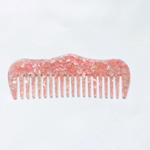 Détail d'un peigne à dents larges rose marbré en acétate antistatique de haute qualité