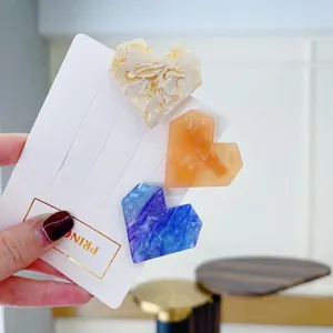 Three-piece acetate heart hair clip set with marble patterns in yellow, pink and blue