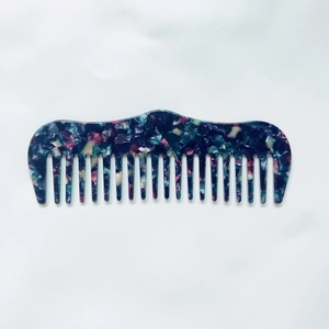 Détail d'un peigne en acétate à motif marbre antistatique avec des dents larges et lisses