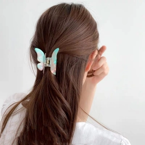 Pince à cheveux papillon élégante en acétate nacré dégradé sur cheveux bruns