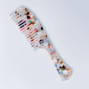 Detailed macro view of acetate hair comb featuring colorful marble textures and wide teeth