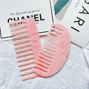 Detail of pink marble cellulose acetate comb set with wide and fine teeth textures