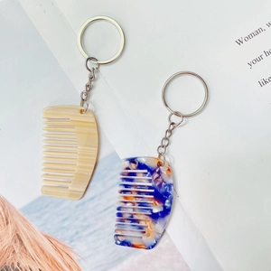 Detail van mini-acetaat kam sleutelhangers met houtnerf en marmeren textuurontwerpen