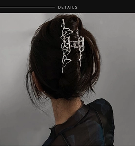 Vue détaillée d'une pince à cheveux irrégulière en métal liquide au fini argenté brillant
