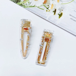 Detail of 2-piece acrylic hair clips set with gold base and silver foil flakes in resin