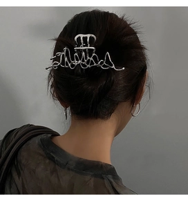 Détail de la pince à cheveux argentée liquide irrégulière sur les cheveux du mannequin