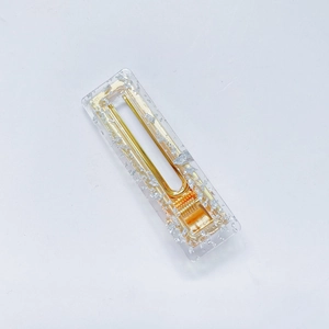 Detail shot of clear acrylic hair clip with silver foil flakes and golden metal spring