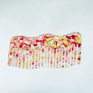 Detail of colorful acetate hair comb with marble pattern and smooth teeth edges