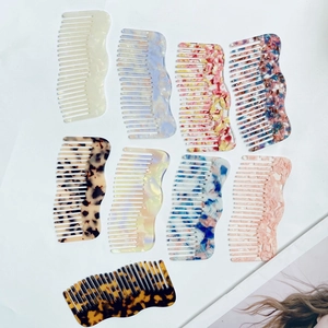 Flat lay of acetate hair combs in marble and tortoise shell patterns on white background