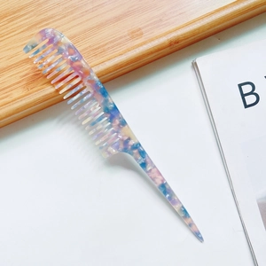 Dettaglio di un pettine a coda in acetato con trama marmorizzata colorata professionale