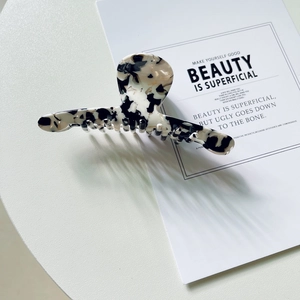 Détail de grande pince à cheveux à motif marbré avec finition acétate rétro sur table