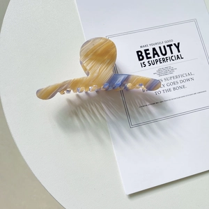 Détail macro d'une grande pince à cheveux en acétate avec texture marbrée ambrée