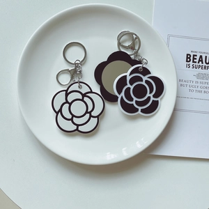 Minimalist camellia flower keychain set with portable hidden mirror in black and white